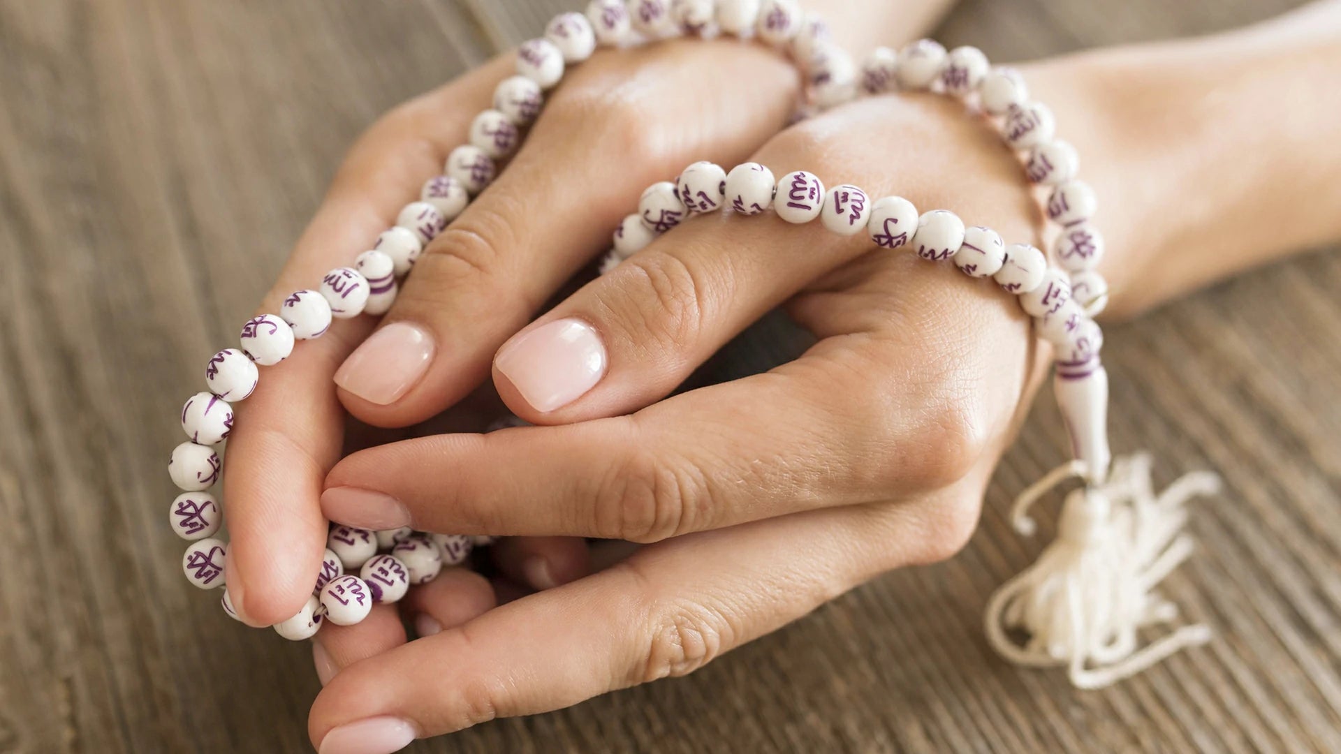 Female hands holding white 108 Buddhist Bodhi prayer beads with Buddhist scriptures