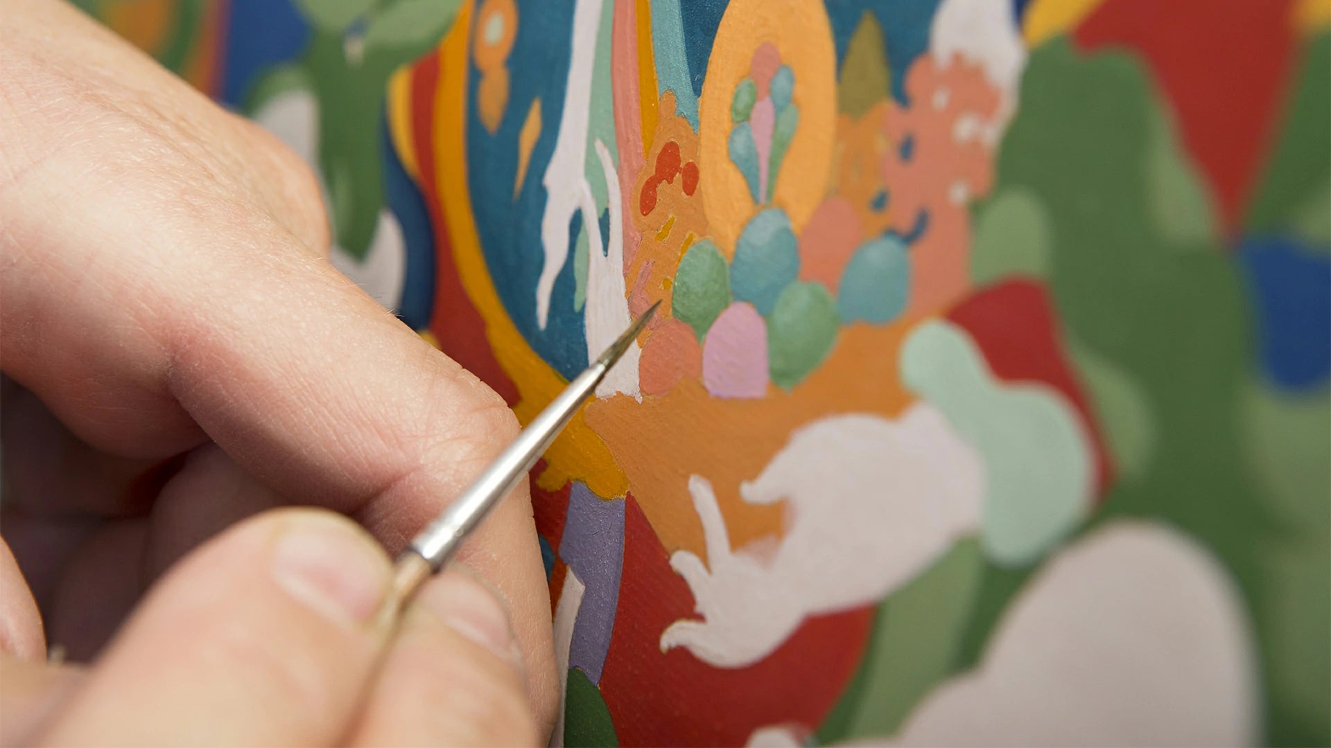 Holding a brush, painting thangka with pure natural mineral paint