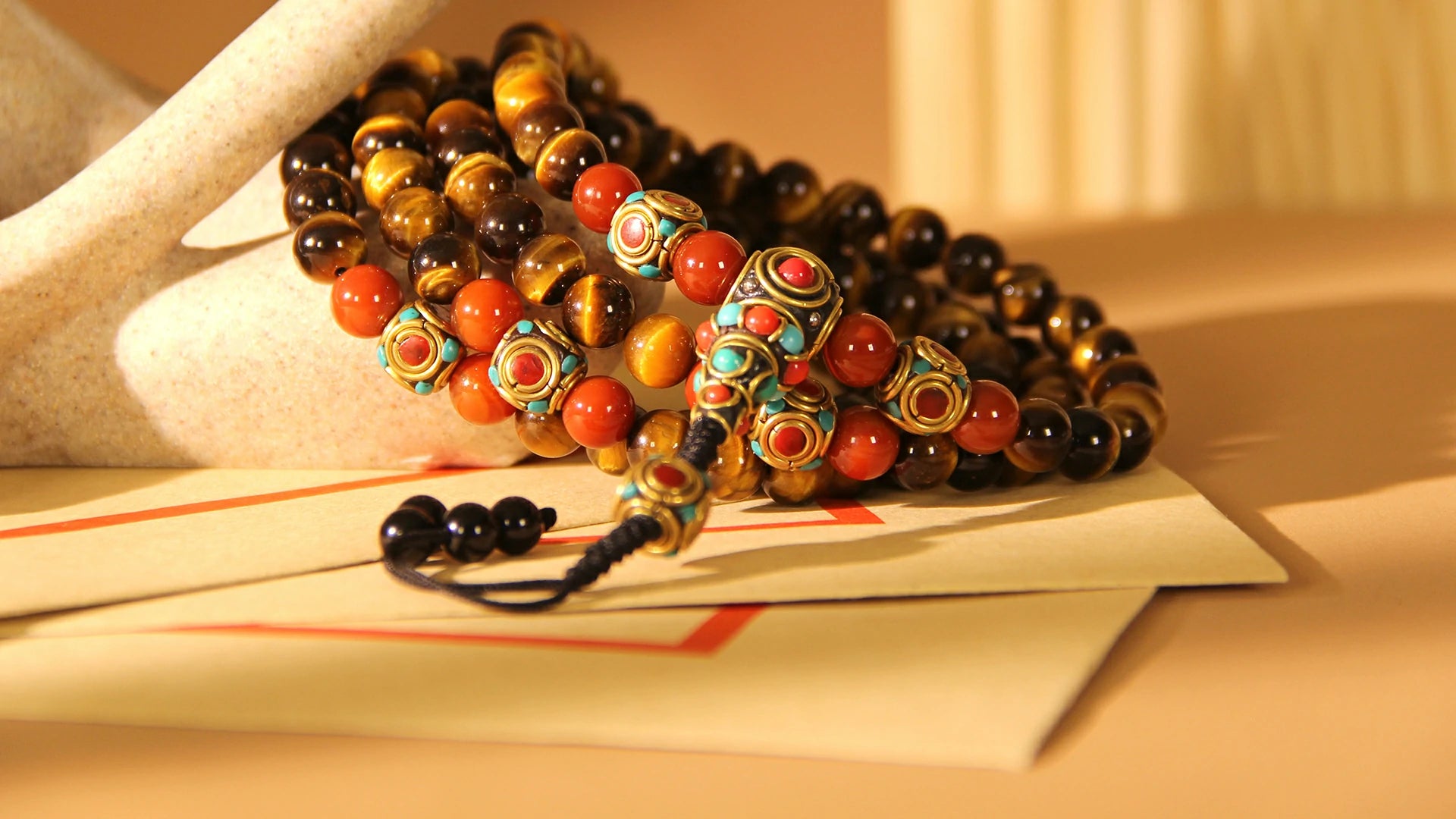 A 108-bead mala crafted from golden tiger's eye stones, with each bead exhibiting the stone's characteristic silky luster and cat's eye effect. Paired with coordinating tassels and counter beads, it is commonly used for meditation, blessings, or as a fashion accessory.