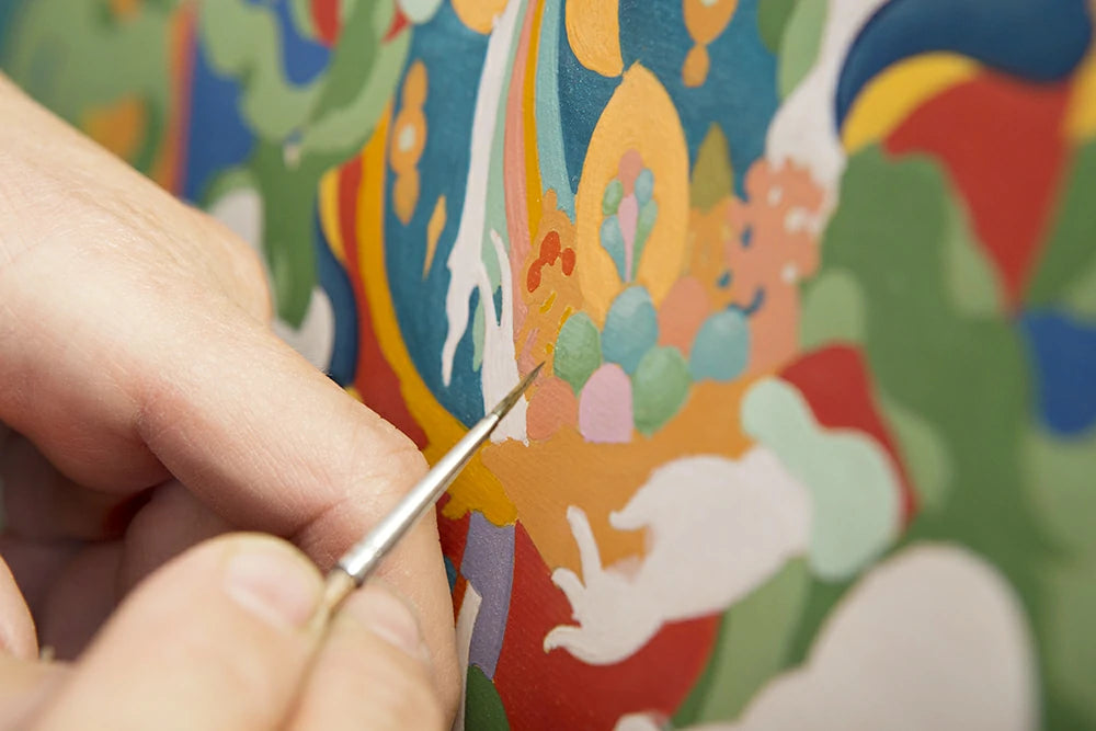Holding a brush, painting thangka with pure natural mineral paint
